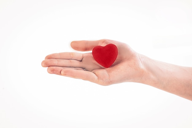 Corazón de papel rojo en la mano femenina