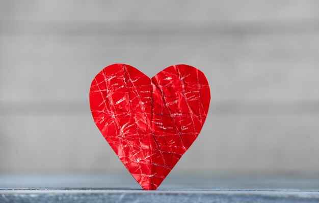 Corazón de papel rojo sobre superficie de madera