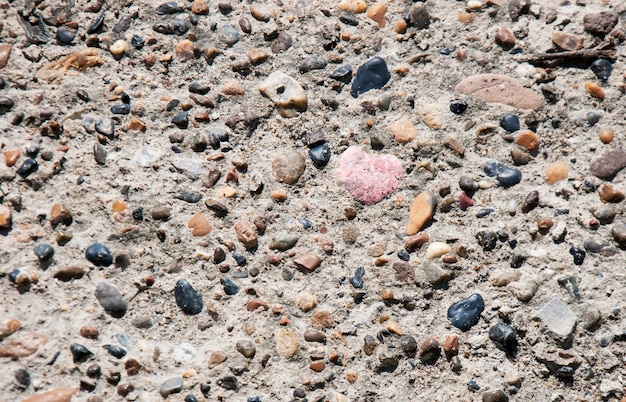 Corazón de piedra entre fondo de piedras naturales multicolores