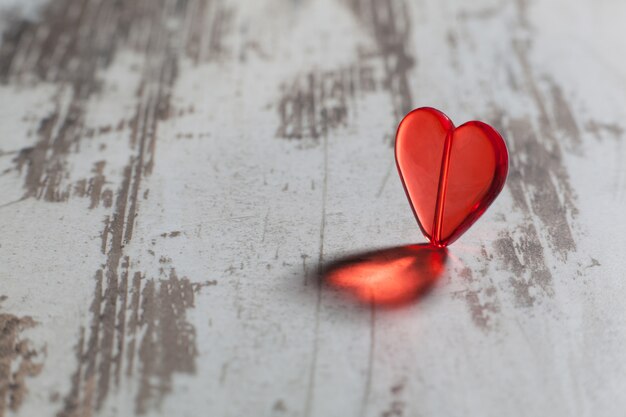 Corazón de plástico rojo sobre una pizarra blanca