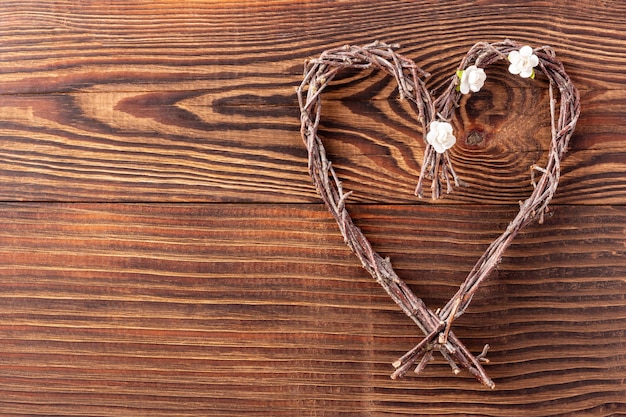 Corazón de ramitas hechas a mano sobre fondo de madera para el día de San Valentín o el día de la madre