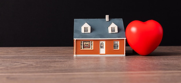 Corazón rojo y casa en miniatura.