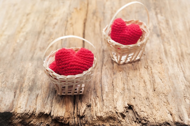 Corazón rojo en la cesta de bambú en madera