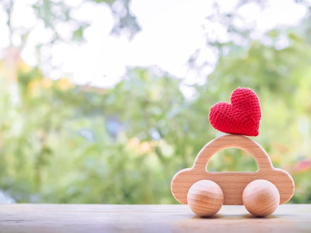 Corazón rojo en coche de juguete de madera para transportar y gestionar el concepto de negocio de éxito Concepto de préstamo de coche