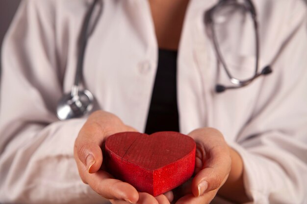 corazón rojo en la mano del médico de cerca