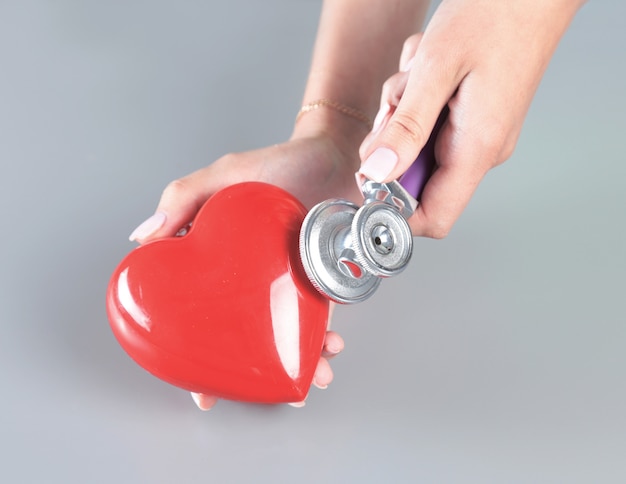 Foto corazón rojo en la mano del médico con estetoscopio