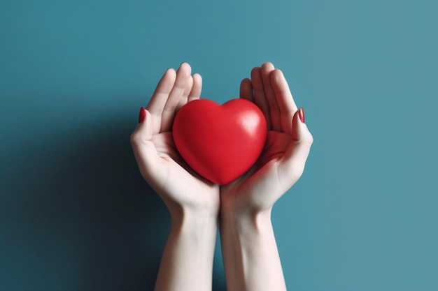 Un corazón rojo en manos de una mujer.