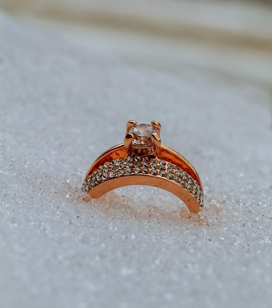 Corazón rojo en la nieve con anillos de boda anillo de bodas de oro en la nieve