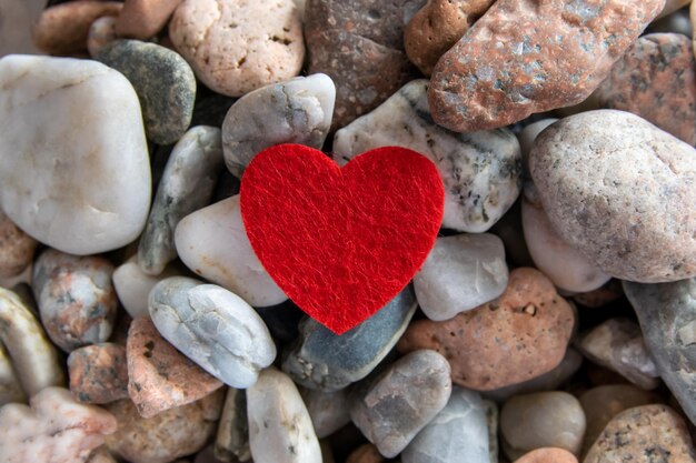 Corazón rojo en las piedras de guijarros del río