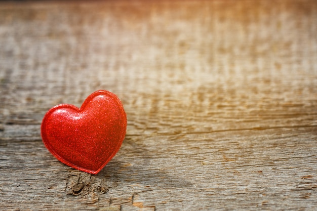 Corazón rojo sobre fondo de madera, tarjeta romántica