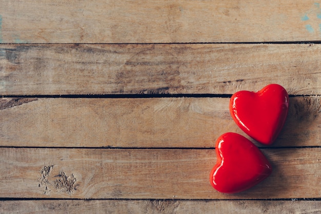 Corazón rojo sobre fondo de mesa de madera con espacio de copia