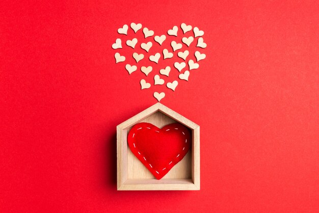 corazón rojo textil en una casa de madera decorada con pequeños corazones