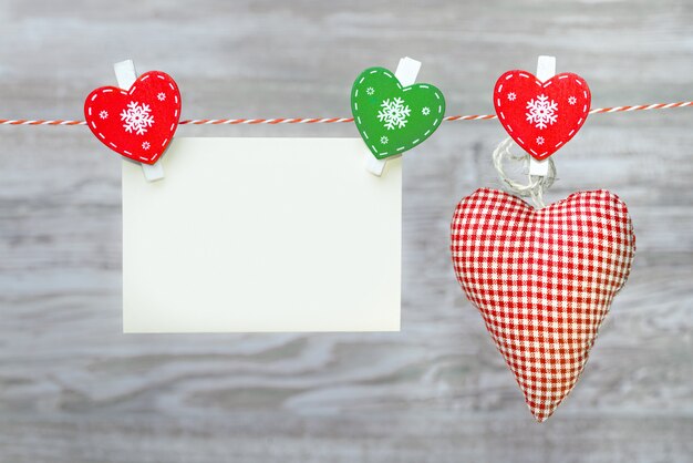 Corazón rojo textil y tarjeta de felicitación en blanco, espacio de copia