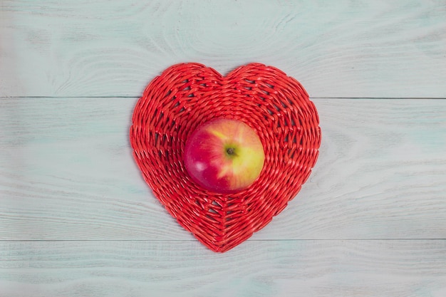 Corazón rojo de tubo de papel de mimbre en tableros de madera blanca amor y concepto de boda Fondo del día de San Valentín