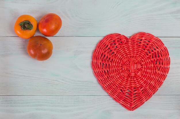 Corazón rojo de tubo de papel de mimbre en tableros de madera blanca amor y concepto de boda Fondo del día de San Valentín