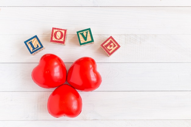 Corazón rojo de la visión superior en el fondo de madera blanco del tablón. Por concepto de amor o día de San Valentín