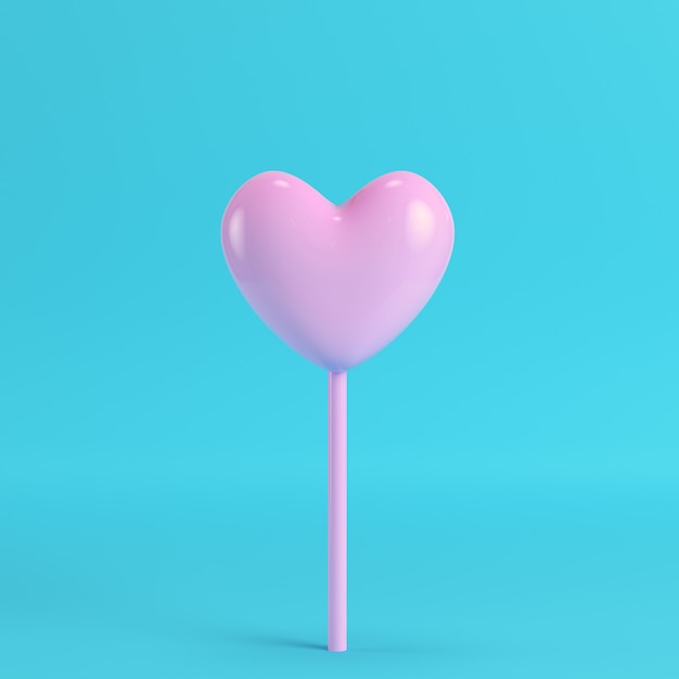 Corazón rosa en un palo sobre fondo azul brillante