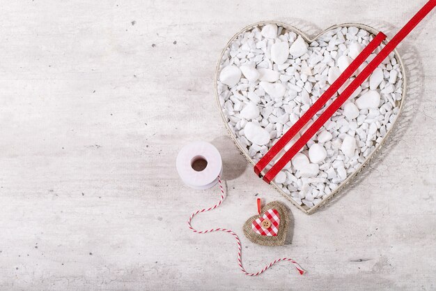 Corazón de San Valentín decorado con rocas blancas sobre fondo de madera brillante. Vista superior, endecha plana. Copia espacio