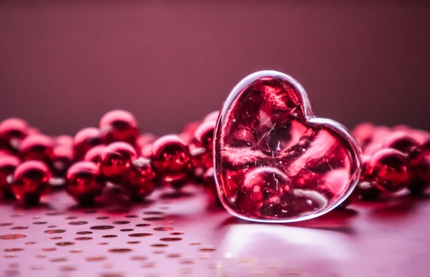 Corazón transparente brillante y un grupo de cuentas rojas Fondo perfecto de la tarjeta de felicitación del día de San Valentín