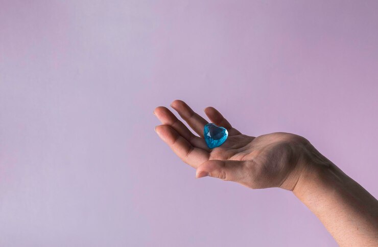 Foto corazón de vidrio azul en la mano de la mujer concepto de amor en el día de san valentín