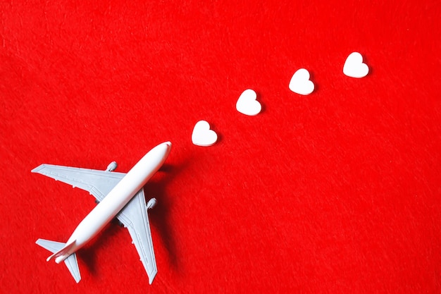 Corazones y un avión sobre un fondo rojo Día de San Valentín Enfoque selectivo