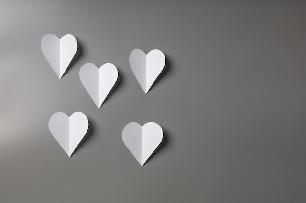 Corazones blancos en pared gris