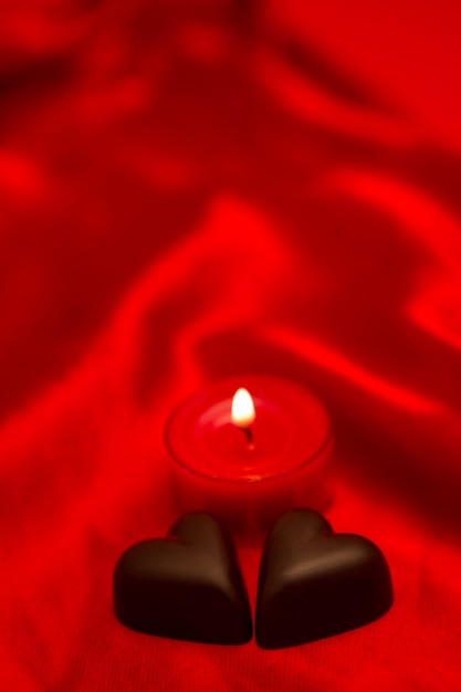 Foto corazones de chocolate y velas encendidas
