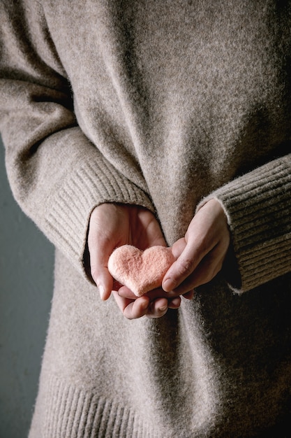 Corazones de fieltro en manos femeninas