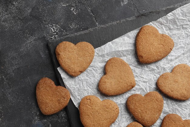 Corazones de galletas caseras deliciosas sobre un fondo oscuro. Vista superior. Lugar para el texto.