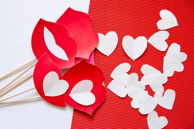 Corazones hechos de papel sobre cartulina roja. Fondo para el día de San Valentín.