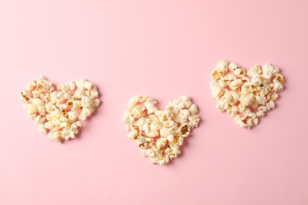 corazones de palomitas de maíz sobre fondo rosa