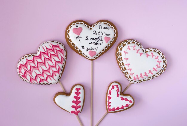 corazones de pan de jengibre en palos sobre fondos de color rosa concepto de amor y romántico