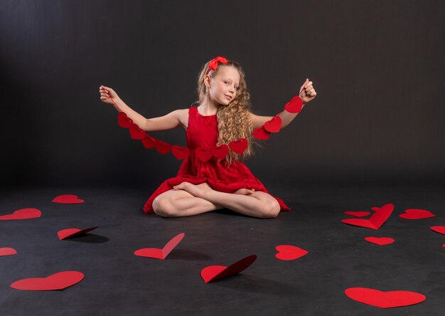 Corazones de papel amor san valentín fondo san valentín en el piso corazones romance espacio inspiración luna de miel emoción fórmula de amor negro en vestido rojo niña descalzo