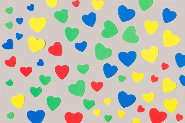 Corazones de papel de colores sobre un fondo gris con espacio de copia