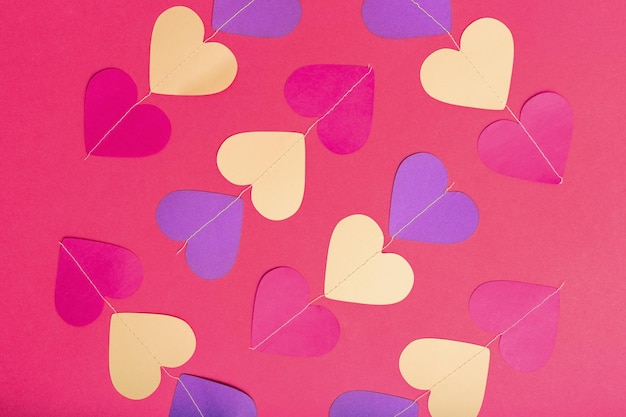 Corazones de papel de colores sobre fondo rojo Lay Flat