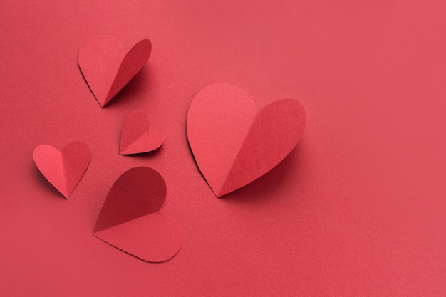 Corazones de papel rojo sobre fondo de papel rojo Concepto de San Valentín