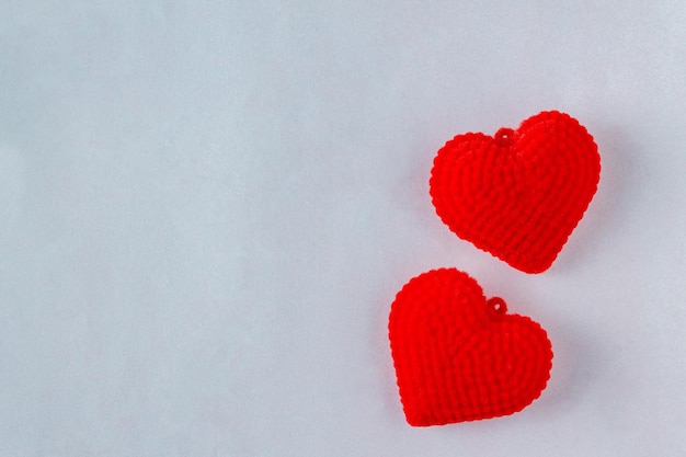 corazones de peluche rojos sobre un fondo gris claro