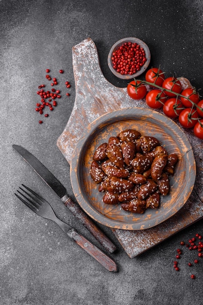 Corazones de pollo fritos en salsa de soja con sal y especias en un plato