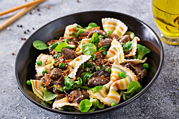 Corazones de pollo con zanahorias en salsa agridulce con pasta farfalle. Ensalada saludable