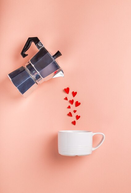 Corazones que brotan de una cafetera géiser en una taza. Concepto de San Valentín. Diseño minimalista. Vista superior