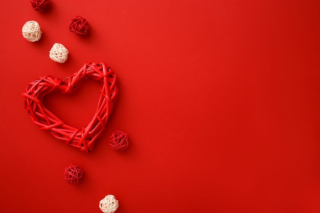 Corazones de ratán con decoración en rojo plano laical. Celebración del día de San Valentín.