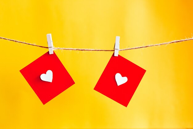 Corazones rojos en cadena sobre pared amarilla. Concepto de San Valentín.