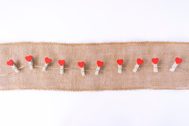 Corazones rojos cuelgan de una cuerda marrón como decoración para el Día de San Valentín. Copia espacio