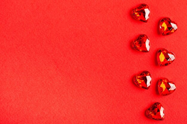 Foto corazones rojos flatlay sobre una superficie roja