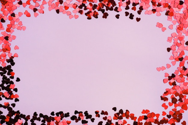 Corazones rojos y rosas sobre un fondo rosa en el día de San Valentín