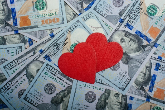 Corazones rojos sobre un fondo de billetes de dólar