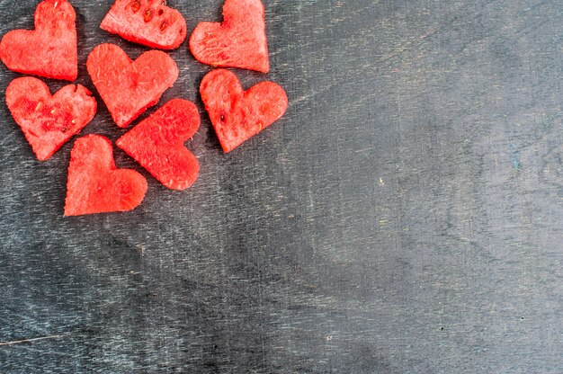 Corazones de sandía en el fondo de madera vieja. Lay Flat