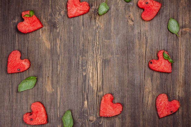 Corazones de sandía en mesa de madera