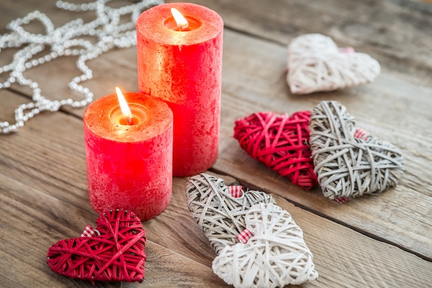 Corazones con velas encendidas en la superficie de madera