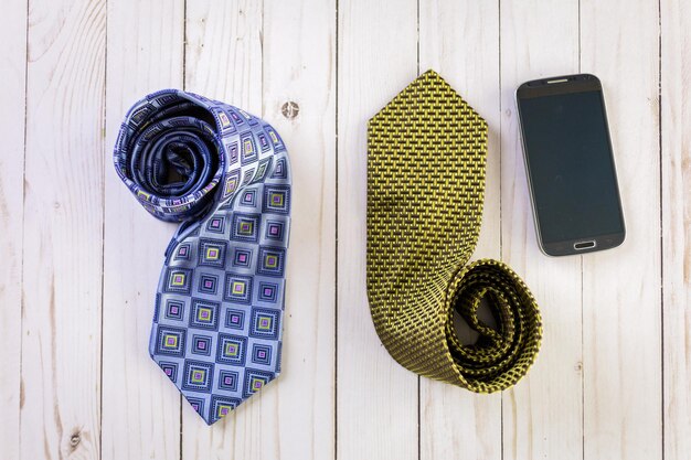 Corbata de hombre con teléfono inteligente sobre un fondo de madera.